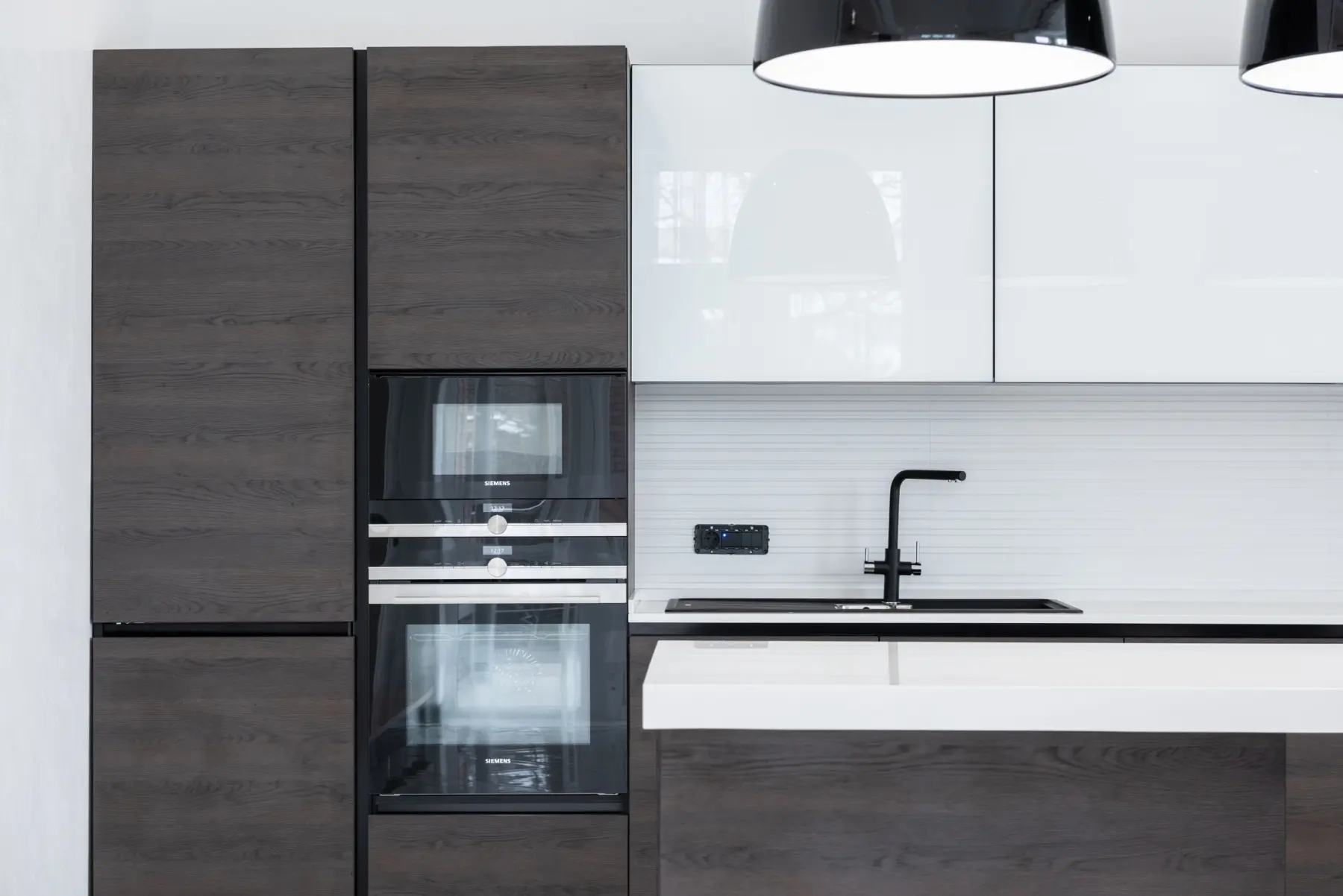 Cuisine contemporaine agencée avec îlot central et rangements toute hauteur