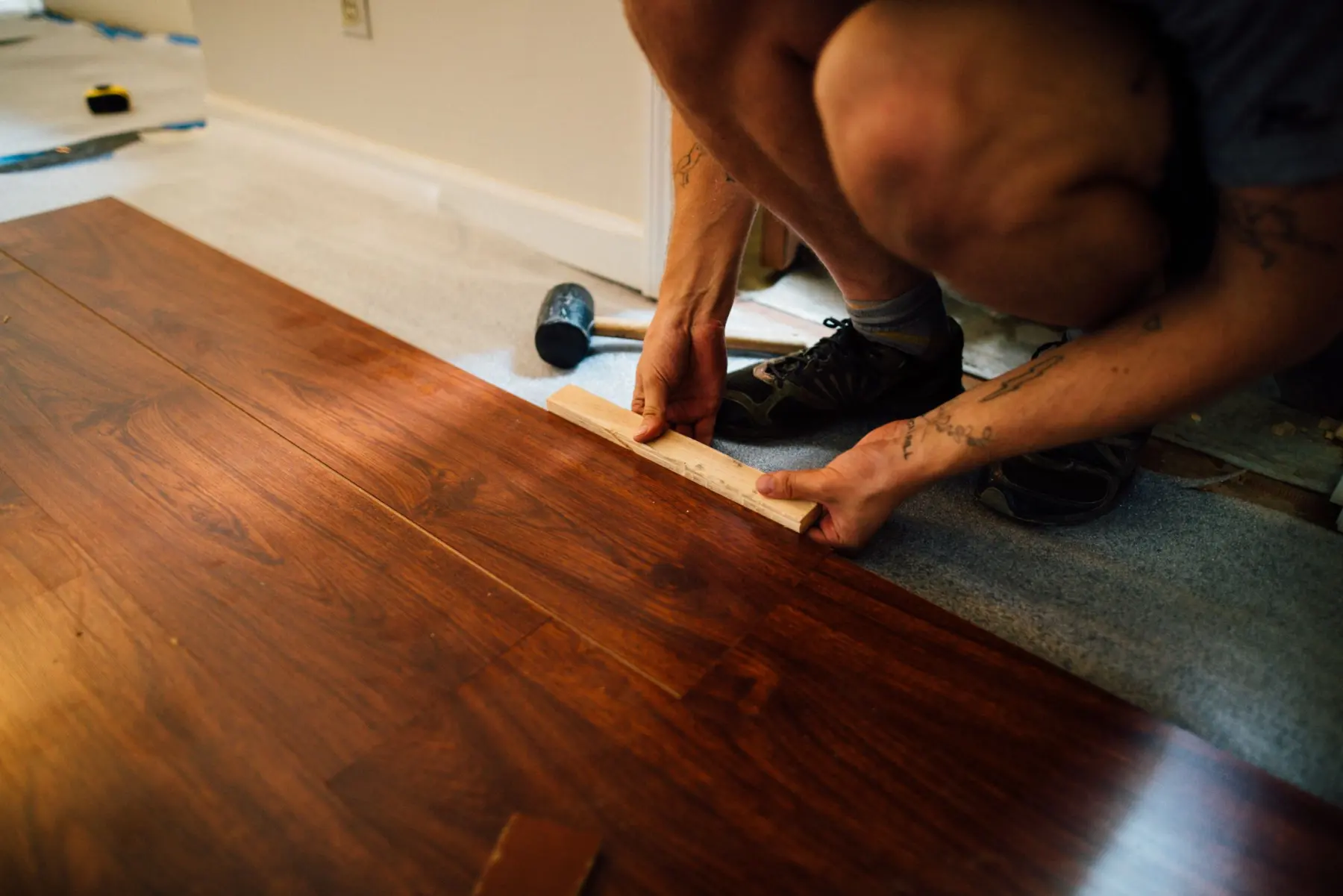 Pose de lames de parquet en bois lors d’une rénovation intérieure