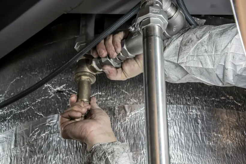 Plombier raccordant des canalisations lors d’une rénovation