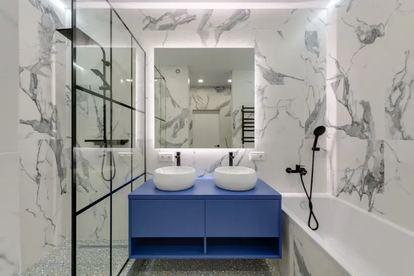 Salle de bain rénovée avec douche vitrée et meuble vasque bleu
