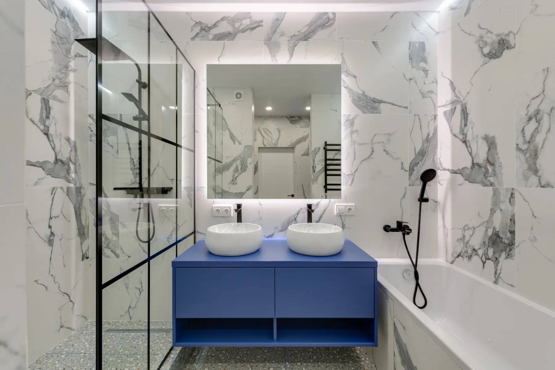 Salle de bain rénovée avec douche vitrée et meuble vasque bleu